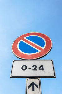 Close-up of road sign against clear blue sky