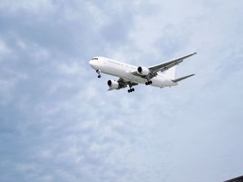 Low angle view of airplane flying against sky