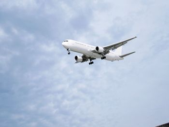 Low angle view of airplane flying against sky