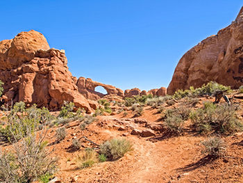 Rock formations on landscape against clear blue sky