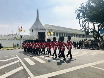 Rear view of people marching against building