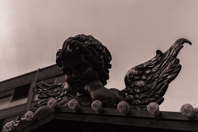 Low angle view of angel statue against sky