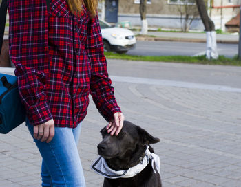 Low section of man with dog standing on street