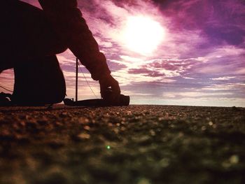 Low section of silhouette man against sky during sunset