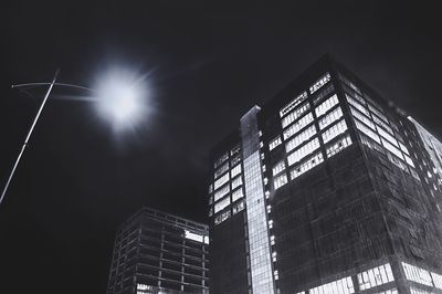 Low angle view of illuminated buildings against sky at night