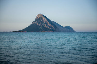 Scenic view of sea and mountains against clear sky