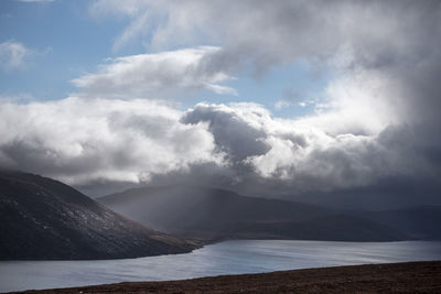 Scenic view of sea and mountains against sky