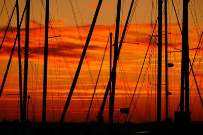 Silhouette of sailboat against orange sky