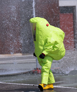 Close-up of person wearing raincoat while walking in city during rainy season