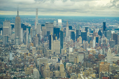 Aerial view of buildings in city against sky