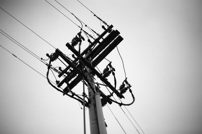 Low angle view of electricity pylon against clear sky