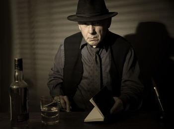 Portrait of man drinking alcohol while sitting at table
