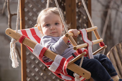 Portrait of cute girl sitting on wood