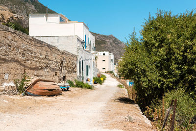 Road amidst buildings against sky