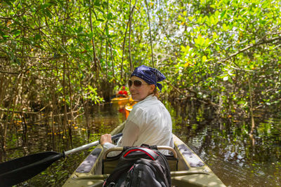 Side view of man sitting in forest