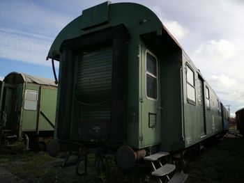 Abandoned train on field against sky