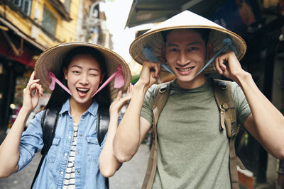 Portrait of smiling couple wearing hat standing in market