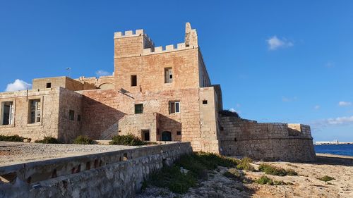 Low angle view of historic building against blue sky