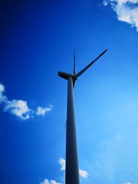 Low angle view of wind turbine against blue sky