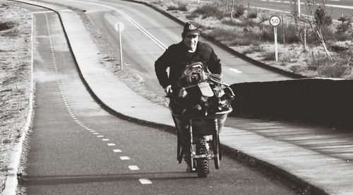 Rear view of person riding bicycle on road