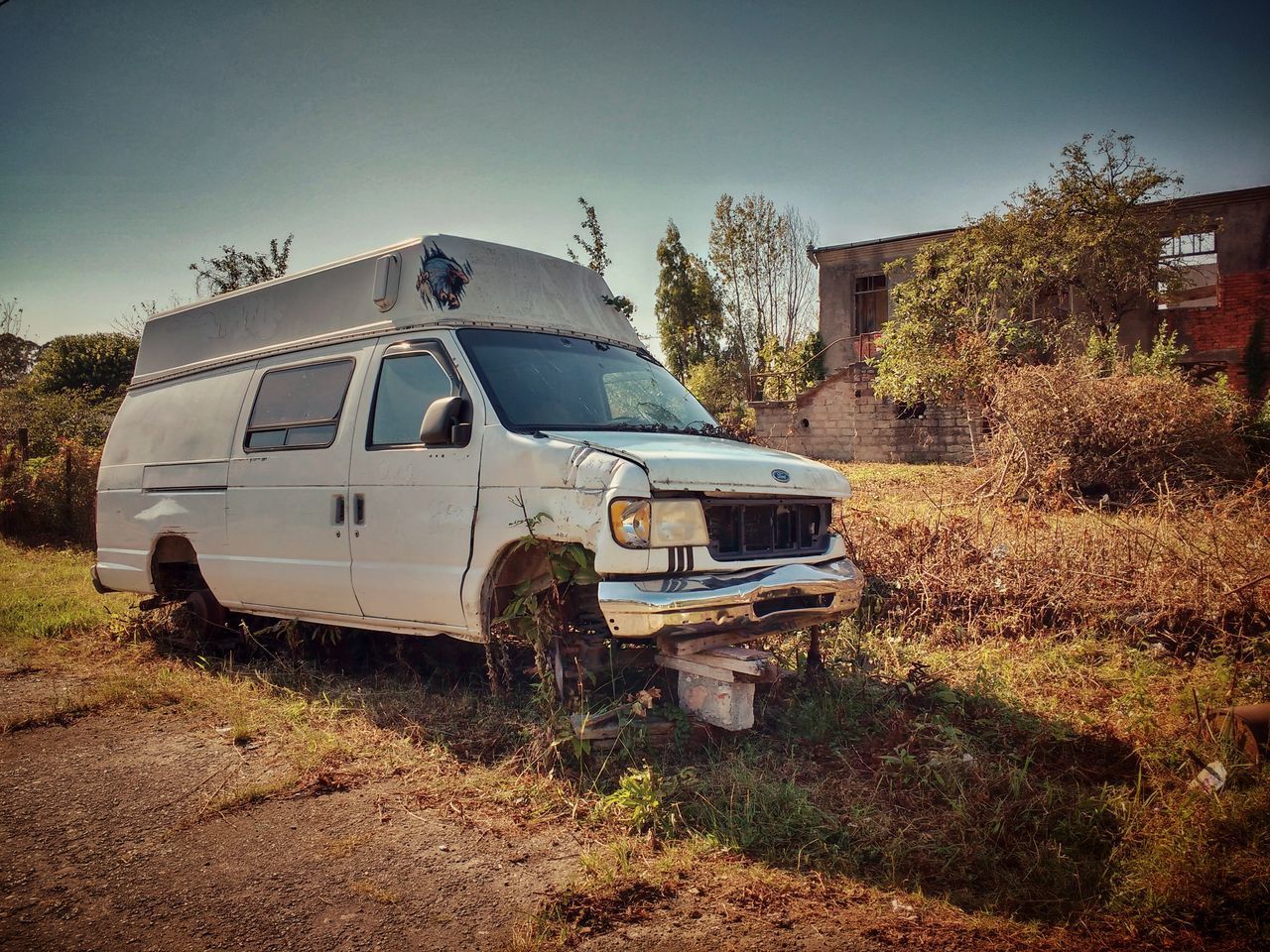 ABANDONED CAR ON LAND AGAINST SKY