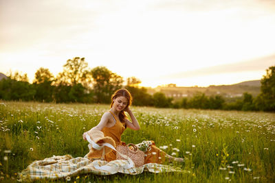 Portrait of young woman sitting on field