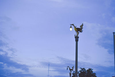 Low angle view of street light against blue sky