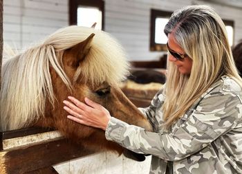 Women and horse in stable