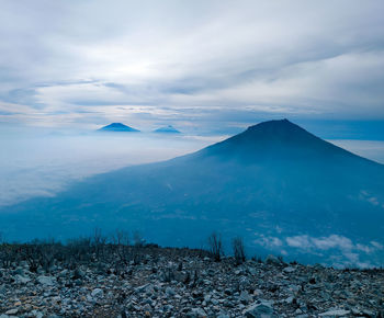 Scenic view of land and mountains against sky