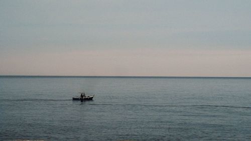 Boat sailing in sea against sky