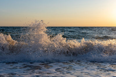 The waves breaking on a beach, forming a spray