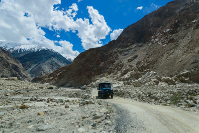 Road by snowcapped mountains against sky