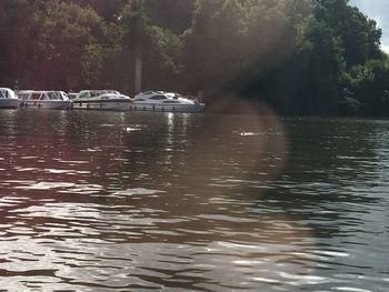 Boats moored on lake against sky