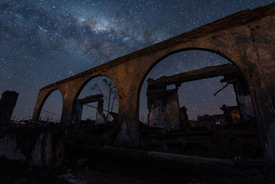 Arch bridge against sky at night