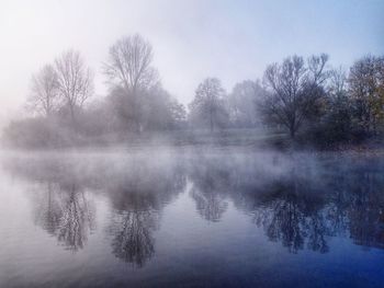 Reflection of trees in lake against sky