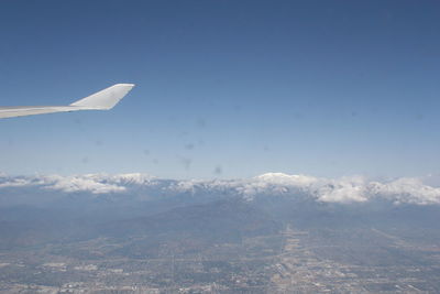 Airplane flying over snowcapped mountains against sky