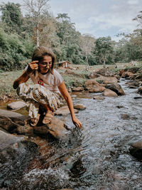 Young woman sitting on rock