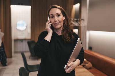 Adult confident business woman freelancer working in a coffee shop cafe using a laptop and phone