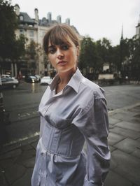 Portrait of woman standing on street in city