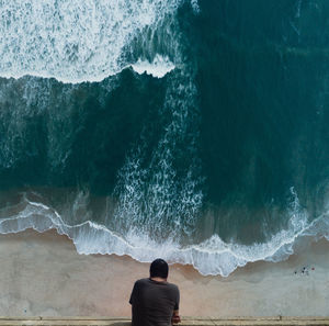 Rear view of man standing at beach