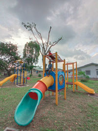 Empty playground against trees in park