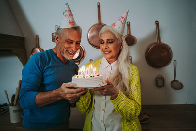 Man and woman standing on birthday cake