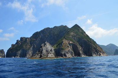 Scenic view of sea and mountain against sky