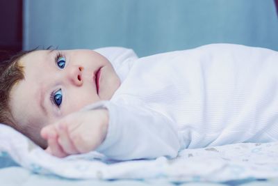 Portrait of cute baby lying on bed