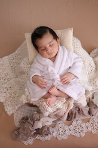 High angle view of cute baby girl lying on bed at home