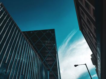 Low angle view of modern buildings against blue sky