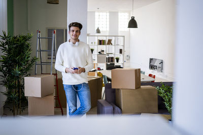 Full length of young man standing against wall at home