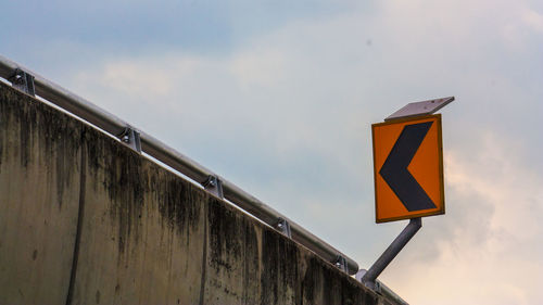 Low angle view of road sign against sky