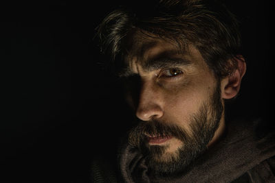 Young man's face standing out from a dark background