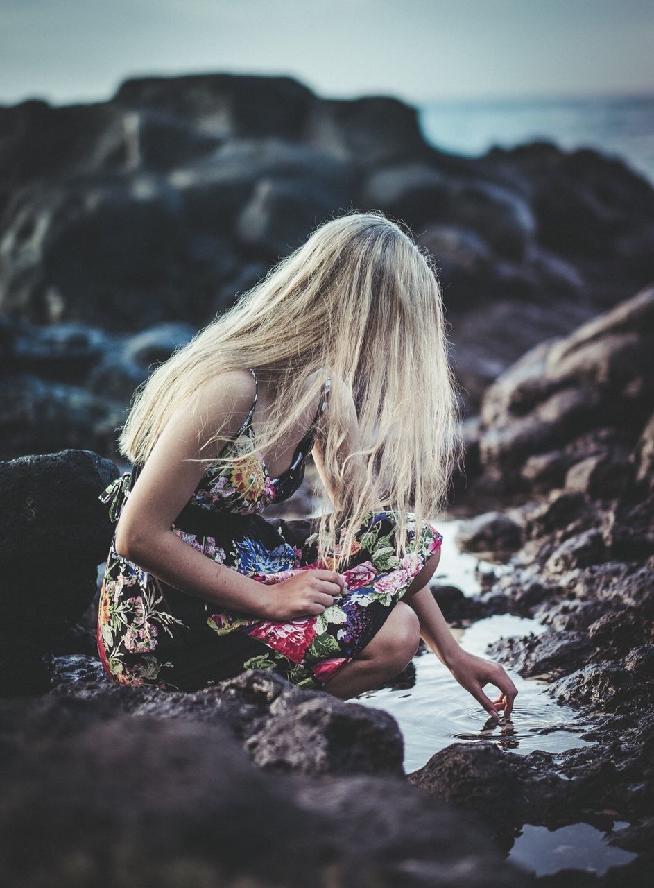 lifestyles, leisure activity, person, beach, young women, focus on foreground, long hair, rear view, full length, young adult, sea, holding, nature, side view, casual clothing, sand, beauty in nature